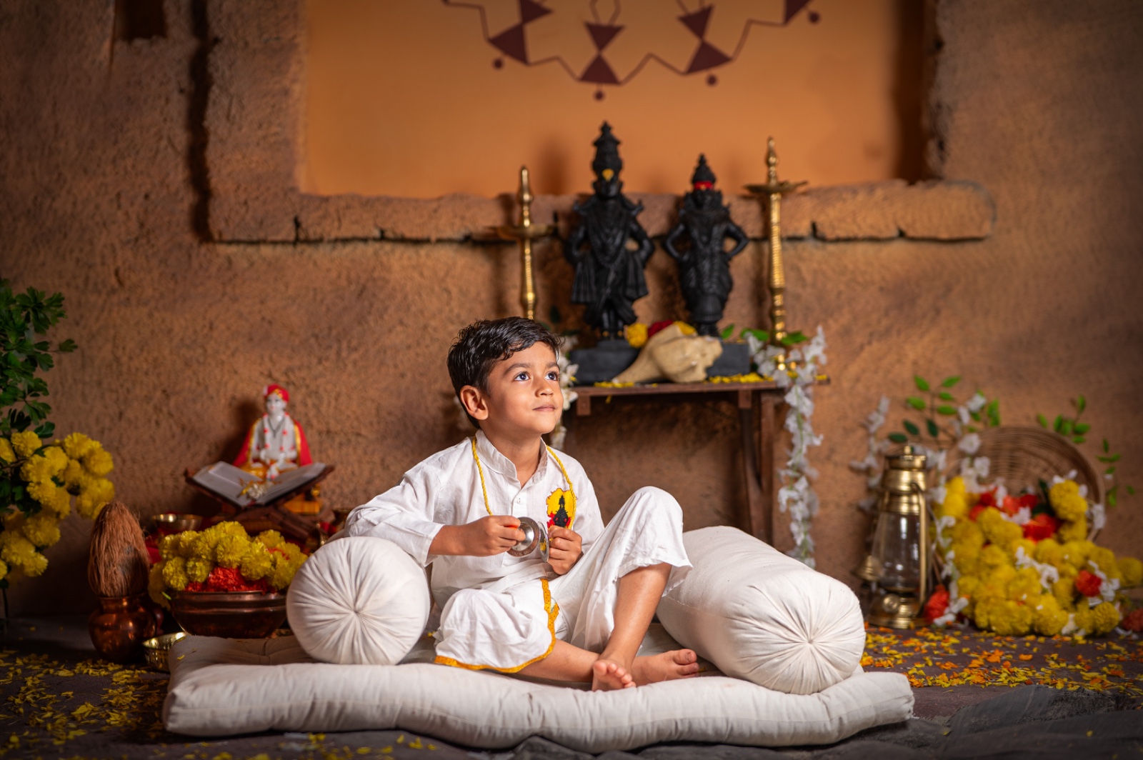 Traditional child portrait with cymbals, flowers and a Vitthal-Rukmini shrine
