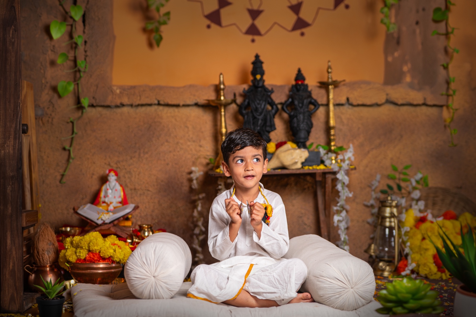 Child in traditional white clothing holding cymbals in a Vitthal-Rukmini themed portrait set